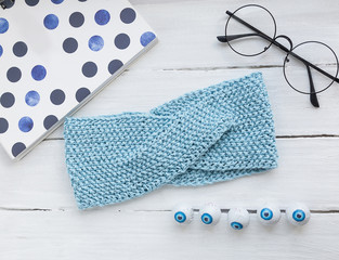 Light texture in white and blue colors: a knitted headband, glasses, a notebook  and eye candy.