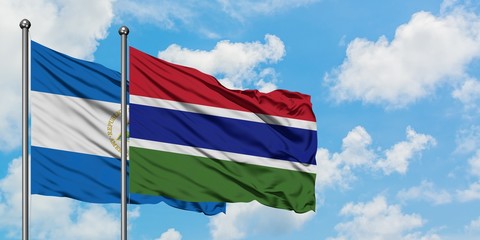 Nicaragua and Gambia flag waving in the wind against white cloudy blue sky together. Diplomacy concept, international relations.
