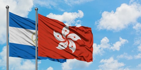 Nicaragua and Hong Kong flag waving in the wind against white cloudy blue sky together. Diplomacy concept, international relations.