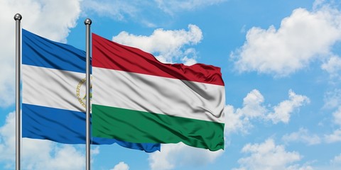 Nicaragua and Hungary flag waving in the wind against white cloudy blue sky together. Diplomacy concept, international relations.