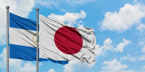Nicaragua and Japan flag waving in the wind against white cloudy blue sky together. Diplomacy concept, international relations.