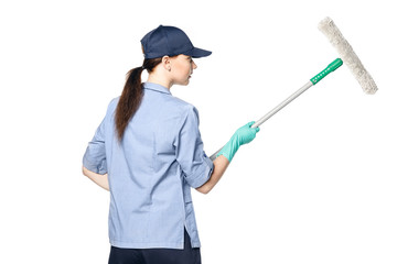 Brunette girl in a baseball cap and cleaning lady uniform washing a window with a special mop Isolated on a white background.