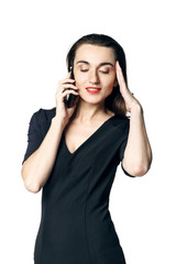 Fototapeta premium Business woman (fatal woman) in a black dress with red lipstick talking on the phone, isolated on a white background.