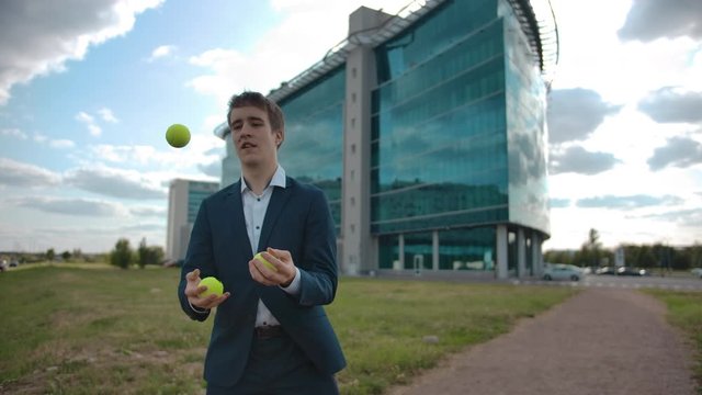 Attractive juggling businessman confidently manage and control business task and difficulties with success urban outdoor with slowmotion
