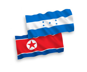 National vector fabric wave flags of North Korea and Honduras isolated on white background. 1 to 2 proportion.