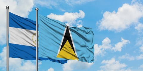Nicaragua and Saint Lucia flag waving in the wind against white cloudy blue sky together. Diplomacy concept, international relations.