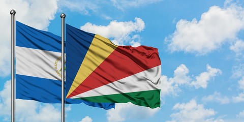 Nicaragua and Seychelles flag waving in the wind against white cloudy blue sky together. Diplomacy concept, international relations.