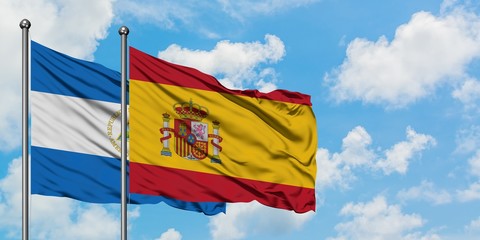 Nicaragua and Spain flag waving in the wind against white cloudy blue sky together. Diplomacy concept, international relations.