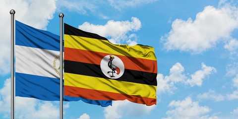 Nicaragua and Uganda flag waving in the wind against white cloudy blue sky together. Diplomacy concept, international relations.