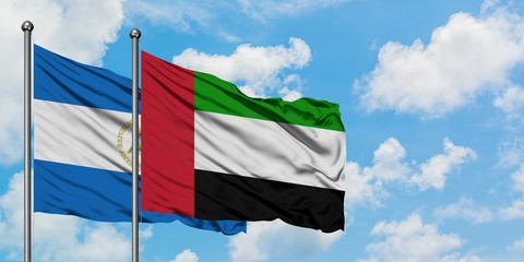 Nicaragua and United Arab Emirates flag waving in the wind against white cloudy blue sky together. Diplomacy concept, international relations.