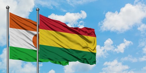 Niger and Bolivia flag waving in the wind against white cloudy blue sky together. Diplomacy concept, international relations.