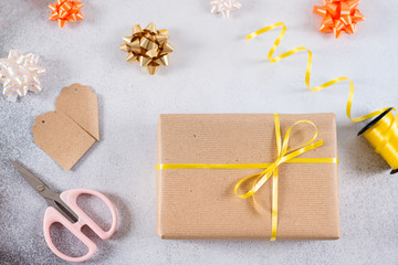 Gift boxes wrapped in craft paper, ribbon, bow and scissors on white background. Christmas, Thanksgiving, birthday presents preparation.