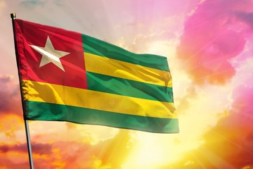 Fluttering Togo flag on beautiful colorful sunset or sunrise background. Success concept.