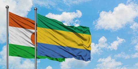 Niger and Gabon flag waving in the wind against white cloudy blue sky together. Diplomacy concept,...