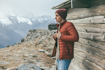 Handsome male model wearing warm sweater and winter coat over mountains with snow