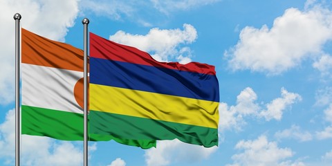 Niger and Mauritius flag waving in the wind against white cloudy blue sky together. Diplomacy concept, international relations.