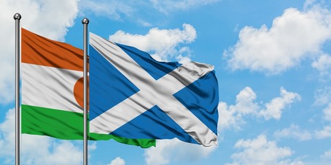 Niger and Scotland flag waving in the wind against white cloudy blue sky together. Diplomacy concept, international relations.