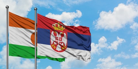 Niger and Serbia flag waving in the wind against white cloudy blue sky together. Diplomacy concept, international relations.