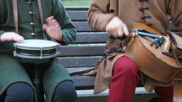 Street musicians dressed in vintage ethnic oriental clothes play music on traditional Middle Eastern musical instruments turkish darbuka and hurdy-gurdy and oud