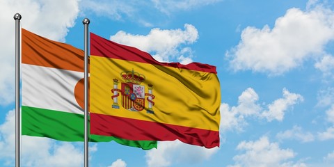 Niger and Spain flag waving in the wind against white cloudy blue sky together. Diplomacy concept, international relations.