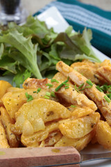 fried potatoes and chicken with salad on a plate