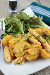 fried potatoes and chicken with salad on a plate