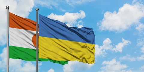 Niger and Ukraine flag waving in the wind against white cloudy blue sky together. Diplomacy concept, international relations.