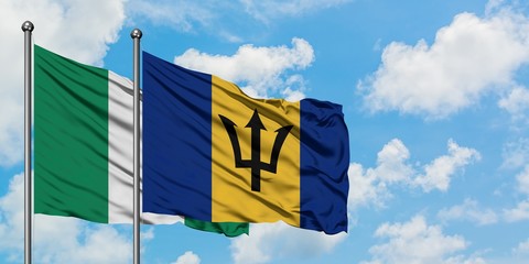 Nigeria and Barbados flag waving in the wind against white cloudy blue sky together. Diplomacy concept, international relations.