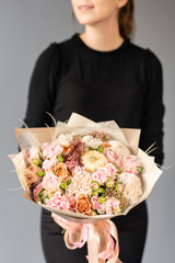 White and pink color. Beautiful bouquet of mixed flowers in womans hands. the work of the florist at a flower shop. Fresh cut flower.