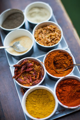 Various colored spices in recipients