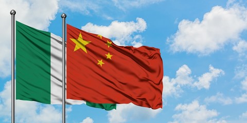 Nigeria and China flag waving in the wind against white cloudy blue sky together. Diplomacy...