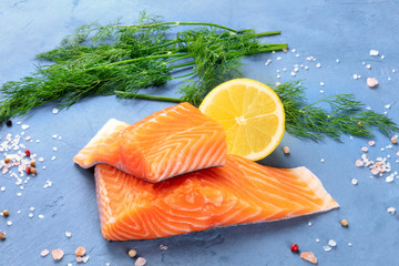 Slices of salmon with lemon and dill, close-up with salt and pepper, cooking fish