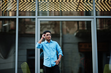 South asian indian male student wear eyeglasses and casual posed outdoor.