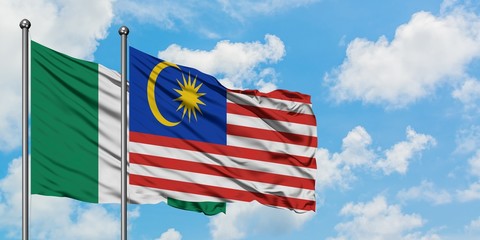 Nigeria and Malaysia flag waving in the wind against white cloudy blue sky together. Diplomacy concept, international relations.