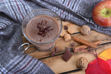 mug of hot chocolate with scarf  in winter and on a wooden table