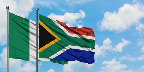 Nigeria and South Africa flag waving in the wind against white cloudy blue sky together. Diplomacy concept, international relations.