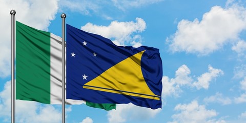 Nigeria and Tokelau flag waving in the wind against white cloudy blue sky together. Diplomacy concept, international relations.