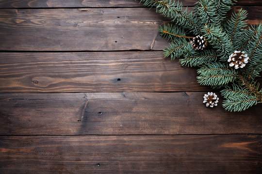 Christmas tree with cones on a dark wooden background. Copy space. Flat lay.