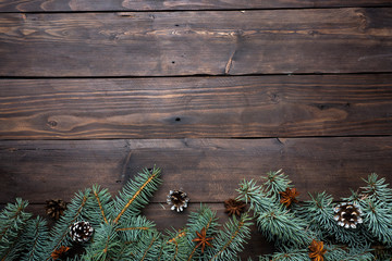 Christmas tree with cones on a dark wooden background. Copy space. Flat lay.
