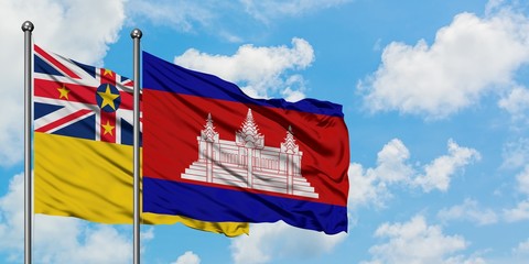 Niue and Cambodia flag waving in the wind against white cloudy blue sky together. Diplomacy concept, international relations.
