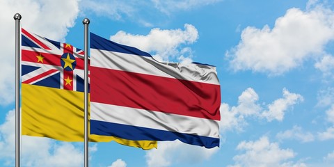 Niue and Costa Rica flag waving in the wind against white cloudy blue sky together. Diplomacy concept, international relations.