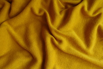 Mustard yellow woolen fabric in soft folds