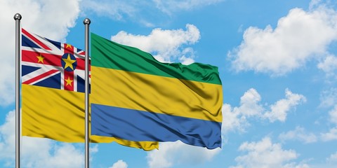 Niue and Gabon flag waving in the wind against white cloudy blue sky together. Diplomacy concept,...