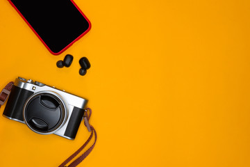 Travel concept with camera and smartphone on orange background	