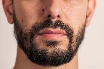 Obraz premium Macro photo man is shaving beard. Beard shaving procedure.Foam and shaver