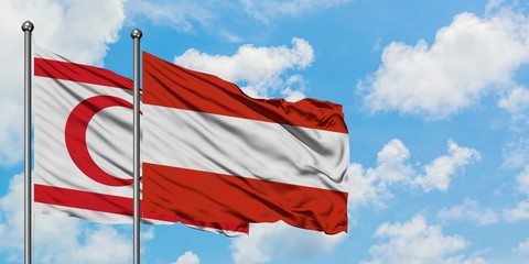 Northern Cyprus and Austria flag waving in the wind against white cloudy blue sky together. Diplomacy concept, international relations.