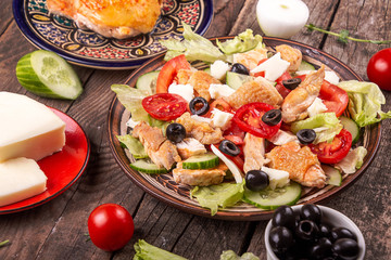 Vegetable and meat salad and ingredients mozzarella, cheese, olives, chicken, cucumber, tomatoes. Low carb dietary food. Top view.