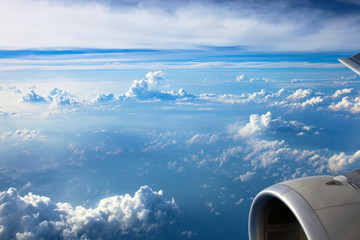 Clouds and sky as seen through window of an aircraft. View from the passenger plane window.