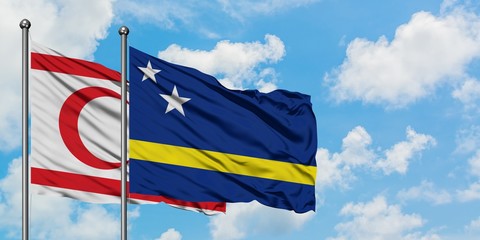Northern Cyprus and Curacao flag waving in the wind against white cloudy blue sky together. Diplomacy concept, international relations.