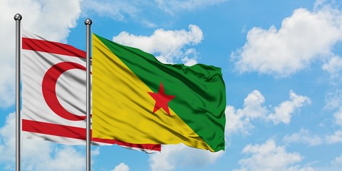 Northern Cyprus and French Guiana flag waving in the wind against white cloudy blue sky together. Diplomacy concept, international relations.